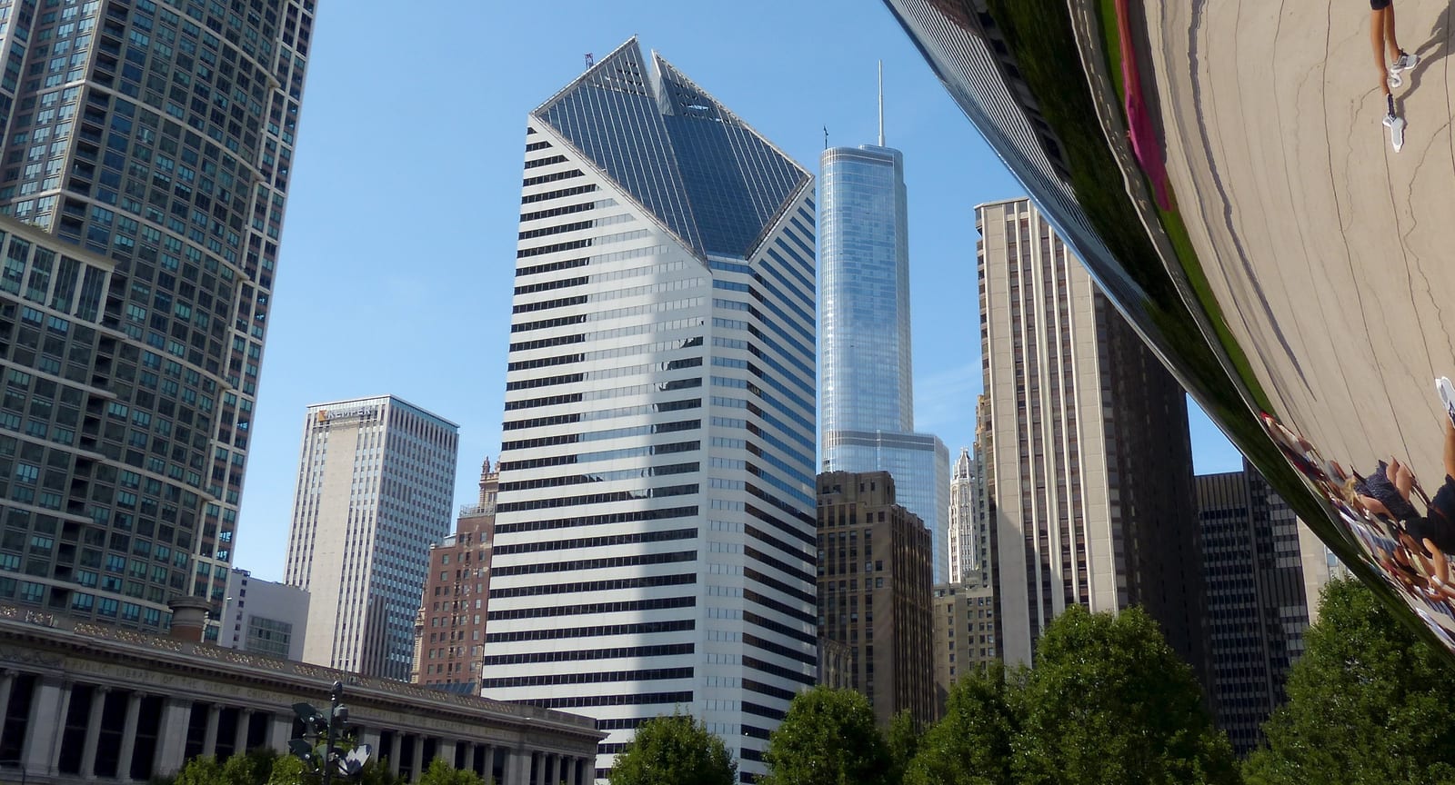 Downtown Chicago towers reflected in the mirrored surface of Cloud Gate in Millennium Park